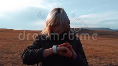 年轻女孩在山上用一只智能手表